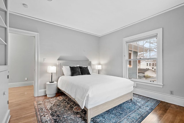 bedroom with wood finished floors and baseboards