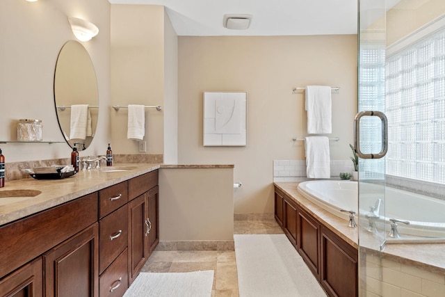 full bathroom with healthy amount of natural light, a garden tub, double vanity, and baseboards