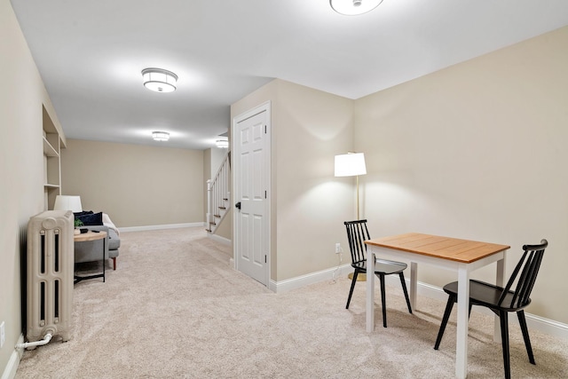 carpeted home office featuring radiator and baseboards