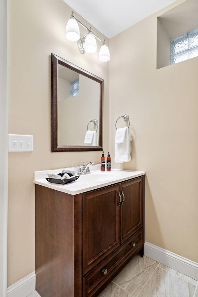 bathroom with vanity, baseboards, and marble look tile flooring