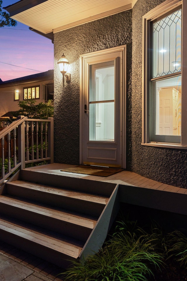 exterior entry at dusk with stucco siding