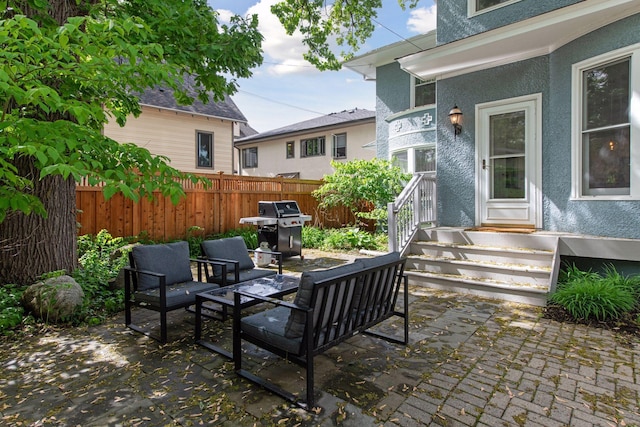 view of patio / terrace featuring a grill, fence, and an outdoor hangout area
