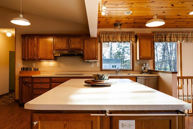 kitchen featuring under cabinet range hood, stainless steel dishwasher, brown cabinets, black electric stovetop, and lofted ceiling