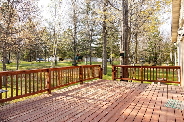 wooden deck with a yard and view of scattered trees