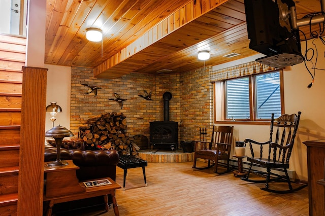 living room featuring wooden ceiling, a wood stove, and wood finished floors