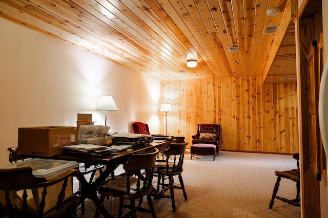 carpeted dining area with wood ceiling and wood walls