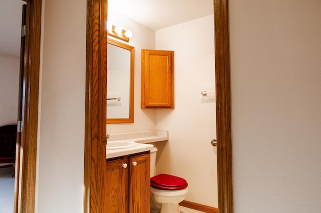 half bath featuring vanity and toilet