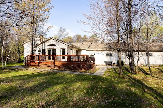 rear view of property with a deck, a lawn, and a chimney