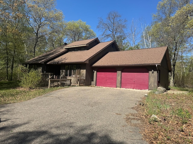 7525 Filbert Ln NE, Turtle River Twp, MN 56601 - view of front facade featuring driveway, a porch, a garage, and roof with shingles