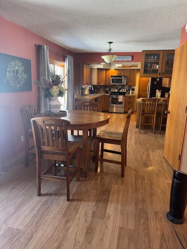 7525 Filbert Ln NE, Turtle River Twp, MN 56601 - dining room with a textured ceiling, light wood-style flooring, and baseboards