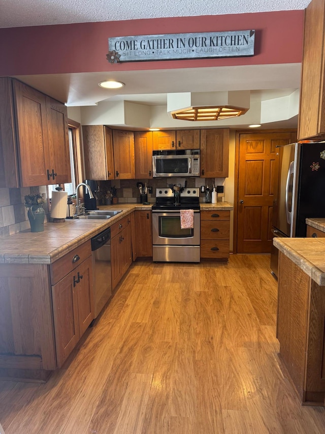 7525 Filbert Ln NE, Turtle River Twp, MN 56601 - kitchen with stainless steel appliances, a sink, light wood-style flooring, and brown cabinets