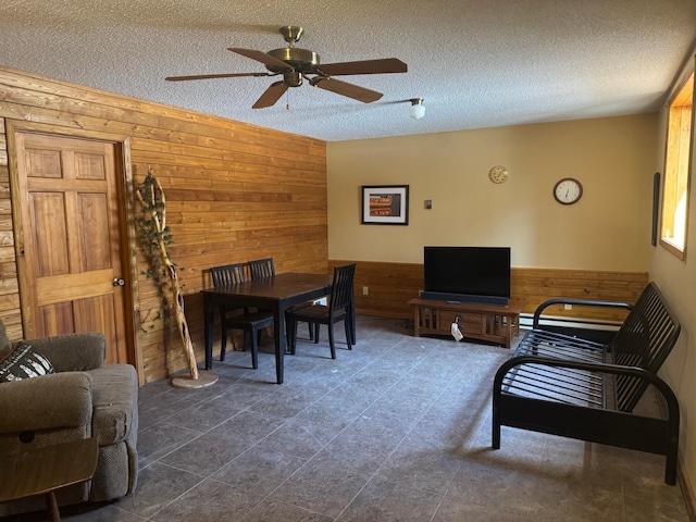 7525 Filbert Ln NE, Turtle River Twp, MN 56601 - living area with wooden walls, a ceiling fan, a textured ceiling, and wainscoting