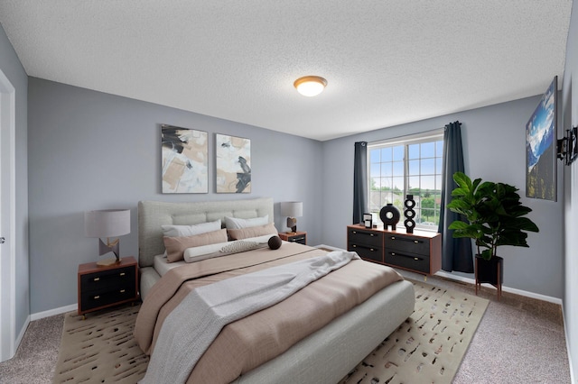 bedroom featuring light colored carpet, baseboards, and a textured ceiling