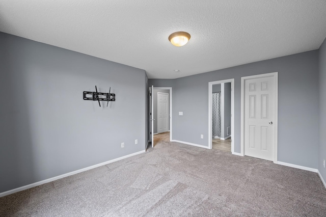 unfurnished bedroom featuring carpet flooring, baseboards, and a textured ceiling