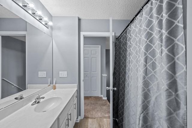 full bath with wood finished floors, a textured ceiling, vanity, and a shower with curtain