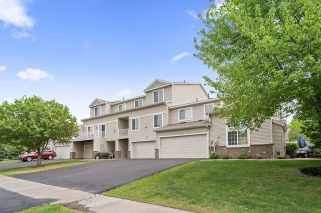 townhome / multi-family property with an attached garage, a front lawn, driveway, and brick siding