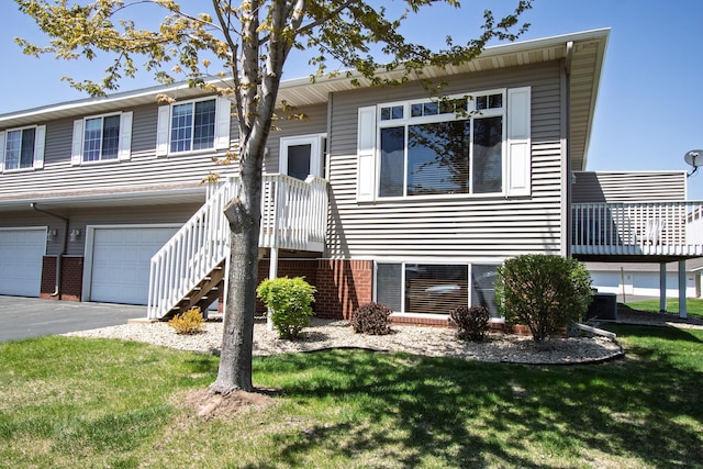 view of front facade featuring a front yard, an attached garage, and driveway
