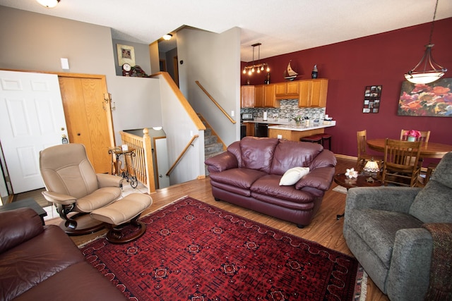 living area with wood finished floors, stairway, and baseboards