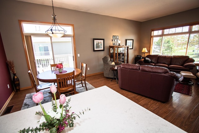 dining space with dark wood finished floors and baseboards