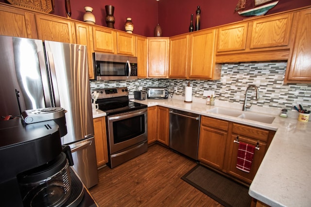 kitchen with stainless steel appliances, a sink, light countertops, and decorative backsplash