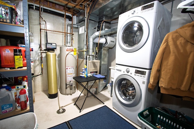 clothes washing area with stacked washing machine and dryer and water heater