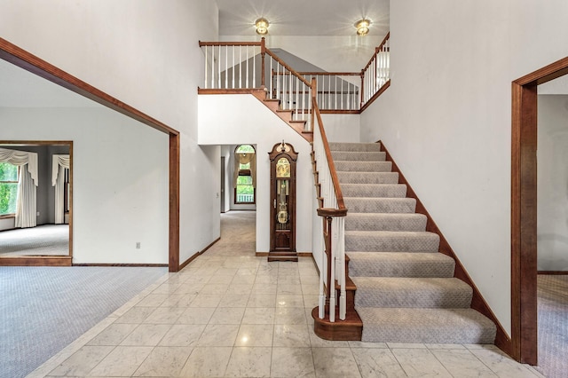 2401 Omeara Ct, Burnsville, MN 55306 - staircase featuring baseboards, a towering ceiling, and carpet