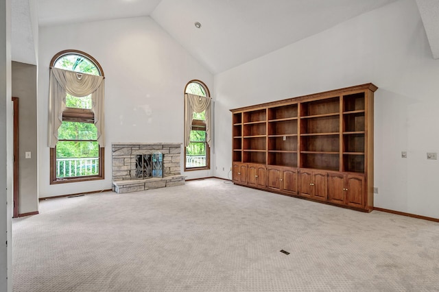 2401 Omeara Ct, Burnsville, MN 55306 - unfurnished living room featuring high vaulted ceiling, healthy amount of natural light, carpet, baseboards, and a stone fireplace
