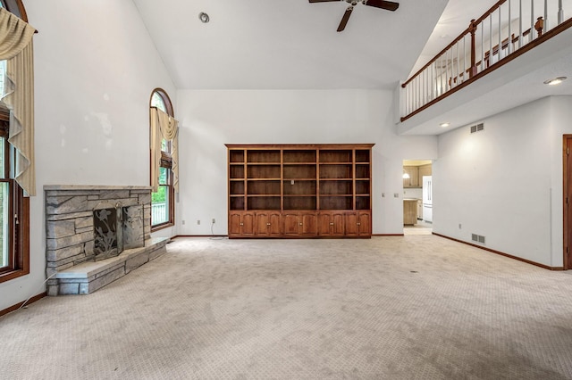 2401 Omeara Ct, Burnsville, MN 55306 - unfurnished living room with high vaulted ceiling, a ceiling fan, baseboards, carpet, and a stone fireplace