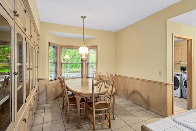 2401 Omeara Ct, Burnsville, MN 55306 - dining area with a wainscoted wall, wooden walls, light tile patterned floors, and washing machine and clothes dryer