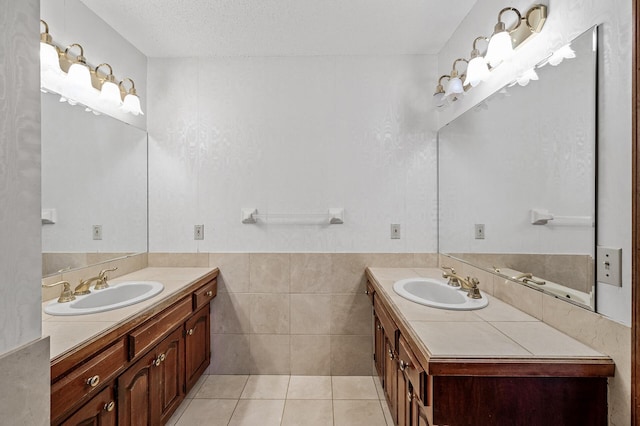 2401 Omeara Ct, Burnsville, MN 55306 - full bathroom featuring two vanities, a wainscoted wall, tile patterned flooring, and tile walls
