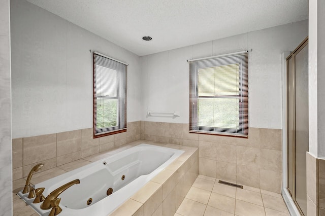 2401 Omeara Ct, Burnsville, MN 55306 - full bathroom with a jetted tub, a shower stall, healthy amount of natural light, a textured ceiling, and tile patterned floors
