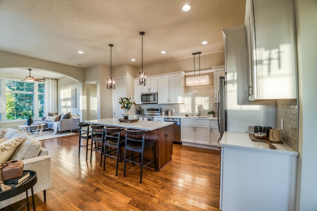 17796 Junelle Ct, Lakeville, MN 55044 - kitchen featuring appliances with stainless steel finishes, open floor plan, a kitchen island, light countertops, and a sink