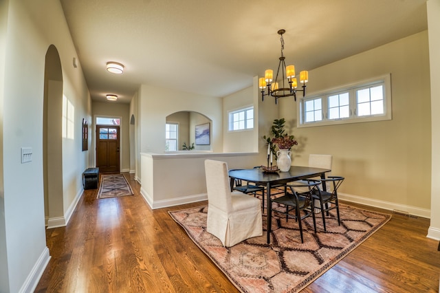 17796 Junelle Ct, Lakeville, MN 55044 - dining space with arched walkways, a chandelier, wood finished floors, and baseboards
