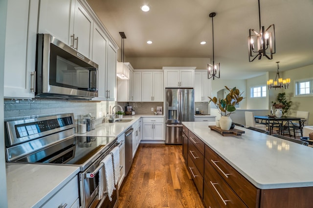17796 Junelle Ct, Lakeville, MN 55044 - kitchen with stainless steel appliances, a chandelier, a sink, dark wood finished floors, and recessed lighting