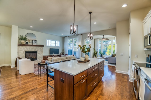 17796 Junelle Ct, Lakeville, MN 55044 - kitchen with appliances with stainless steel finishes, open floor plan, a breakfast bar area, plenty of natural light, and recessed lighting