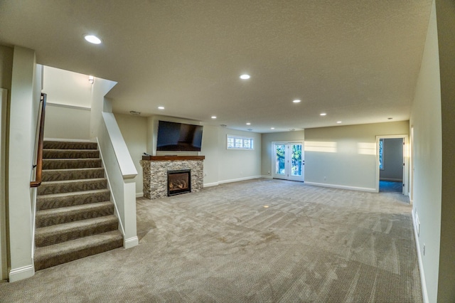 17796 Junelle Ct, Lakeville, MN 55044 - unfurnished living room with carpet, recessed lighting, a stone fireplace, baseboards, and stairs