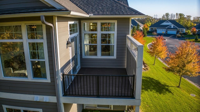 17796 Junelle Ct, Lakeville, MN 55044 - view of side of property featuring a balcony, a shingled roof, a yard, and a detached garage