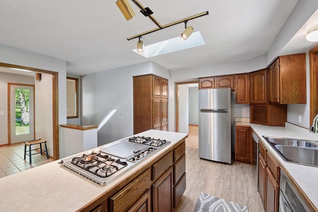 7081 Shawnee Ln, Chanhassen, MN 55317 - kitchen with a sink, stainless steel appliances, track lighting, light countertops, and brown cabinets
