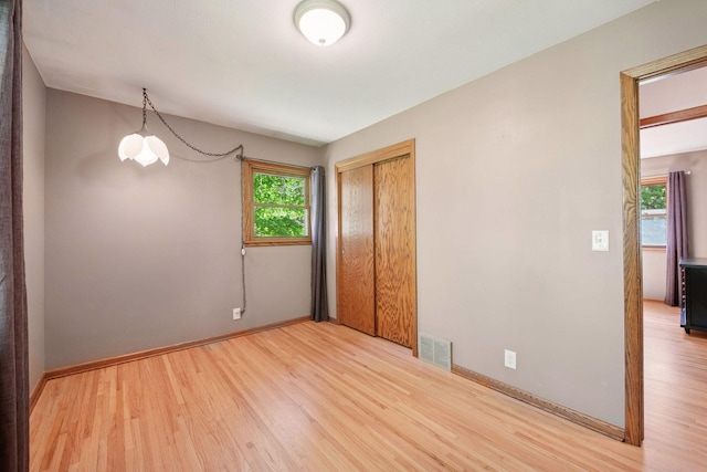 7081 Shawnee Ln, Chanhassen, MN 55317 - unfurnished bedroom featuring wood finished floors, a closet, and baseboards