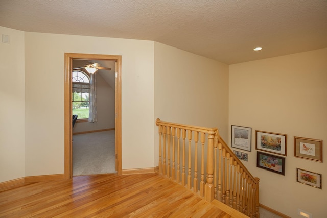 770 Valley View Rd SW, Oronoco, MN 55960 - staircase featuring wood finished floors, baseboards, a textured ceiling, and recessed lighting