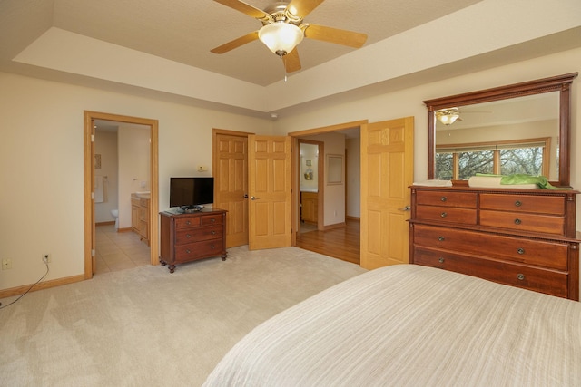 770 Valley View Rd SW, Oronoco, MN 55960 - bedroom with light carpet, baseboards, connected bathroom, a raised ceiling, and a ceiling fan
