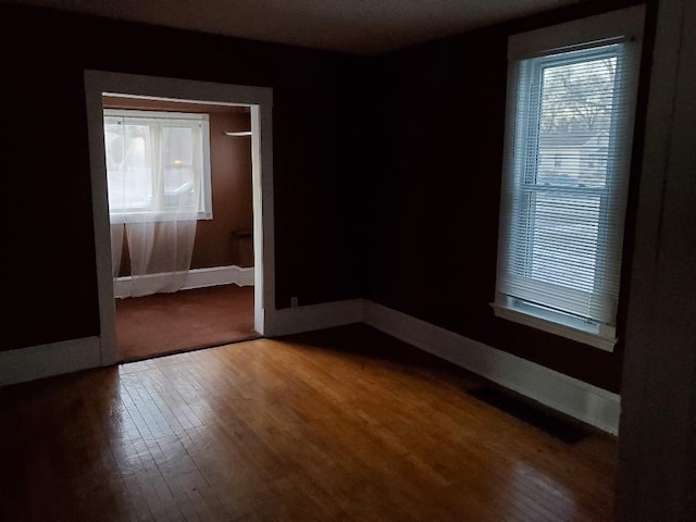 4422 Bryant Ave N, Minneapolis, MN 55412 - empty room featuring wood finished floors, healthy amount of natural light, and baseboards