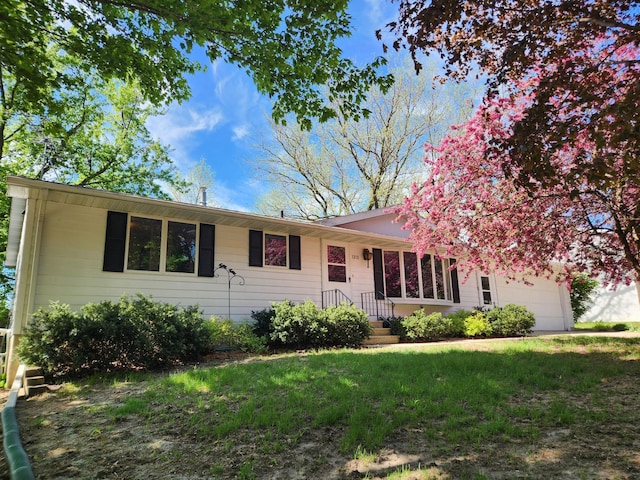 ranch-style house featuring an attached garage and a front yard