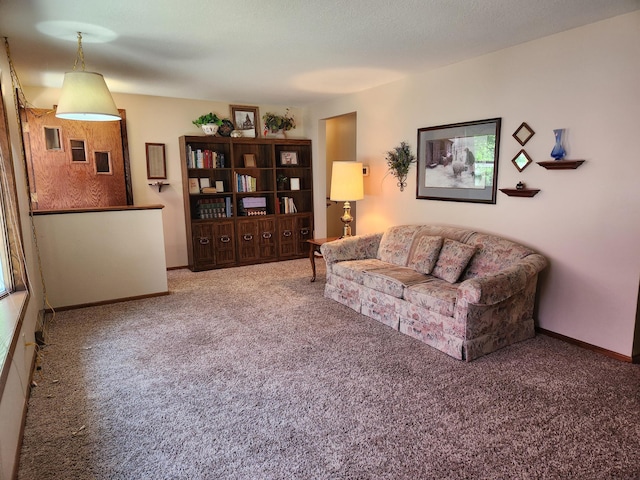 carpeted living area with baseboards