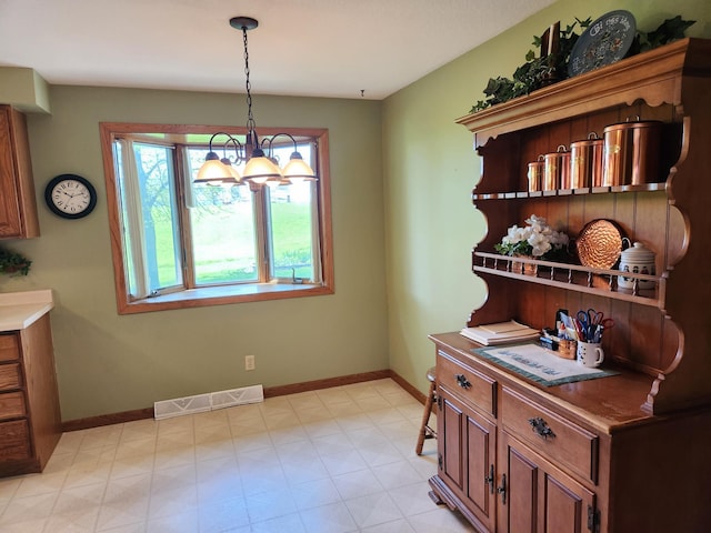 dining room with baseboards, a chandelier, and light floors