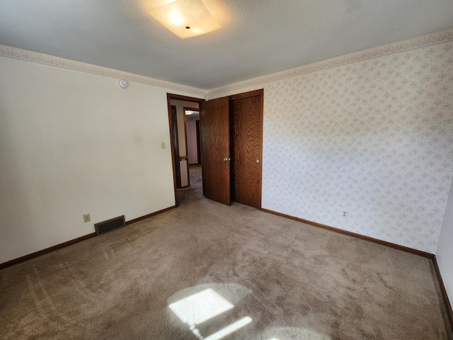 carpeted empty room with baseboards
