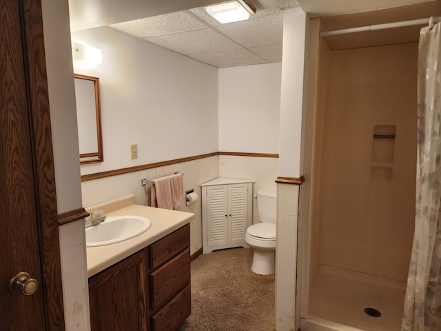 full bathroom with a drop ceiling, a shower stall, vanity, and toilet