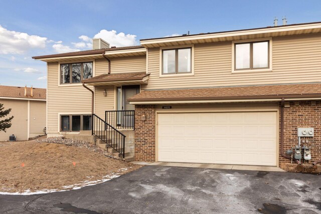14870 Endicott Way Unit 20, Apple Valley, MN 55124 - view of front of property featuring asphalt driveway, brick siding, a garage, and a chimney