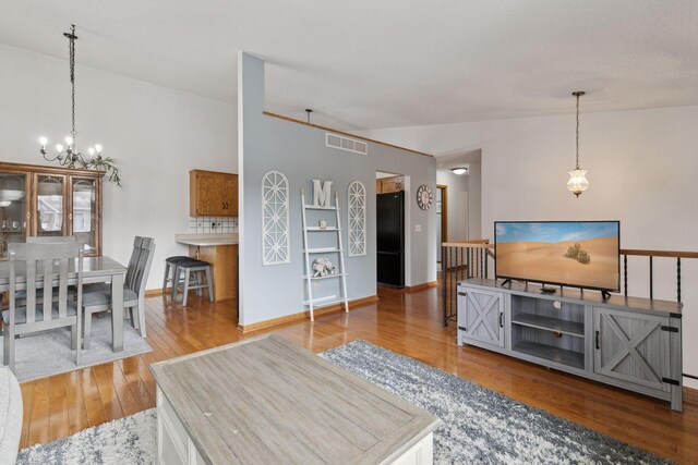 14870 Endicott Way Unit 20, Apple Valley, MN 55124 - living area featuring vaulted ceiling, a chandelier, wood finished floors, and baseboards