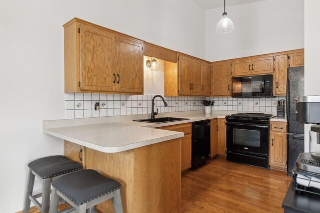 14870 Endicott Way Unit 20, Apple Valley, MN 55124 - kitchen featuring black appliances, a sink, a peninsula, backsplash, and wood finished floors